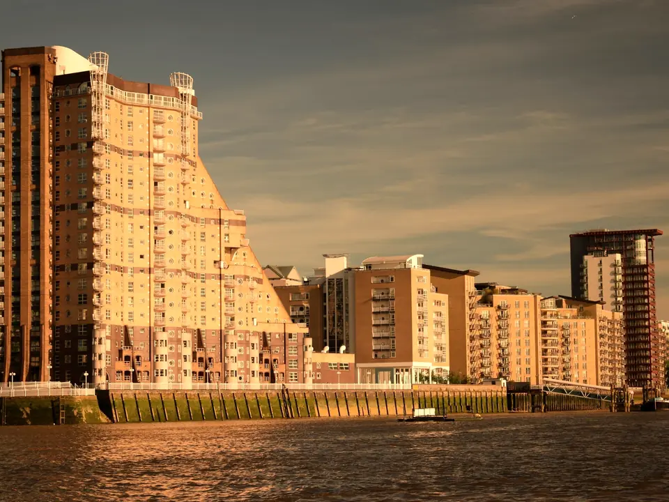 Riverside apartment buildings in London’s Docklands in warm evening sun, the Thames in front