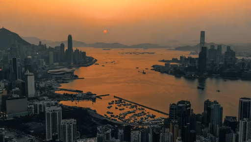 Hong Kong’s harbour from above at sunset, towers on both shores